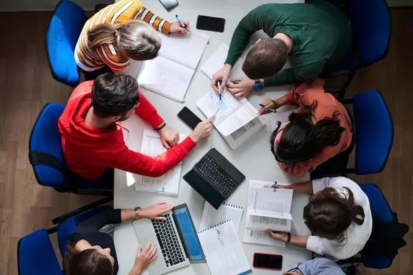 A imagem mostra um grupo de estudantes de Engenharia de Produção reunidos em uma sala de estudos, concentrados na troca de conhecimentos e na resolução de problemas acadêmicos. Sentados ao redor de uma mesa, eles compartilham ideias e revisam conceitos complexos, destacando-se pela colaboração e pela dedicação aos estudos. Essa interação fortalece o aprendizado em equipe e prepara os alunos para enfrentar os desafios da Engenharia de Produção com confiança e competência.