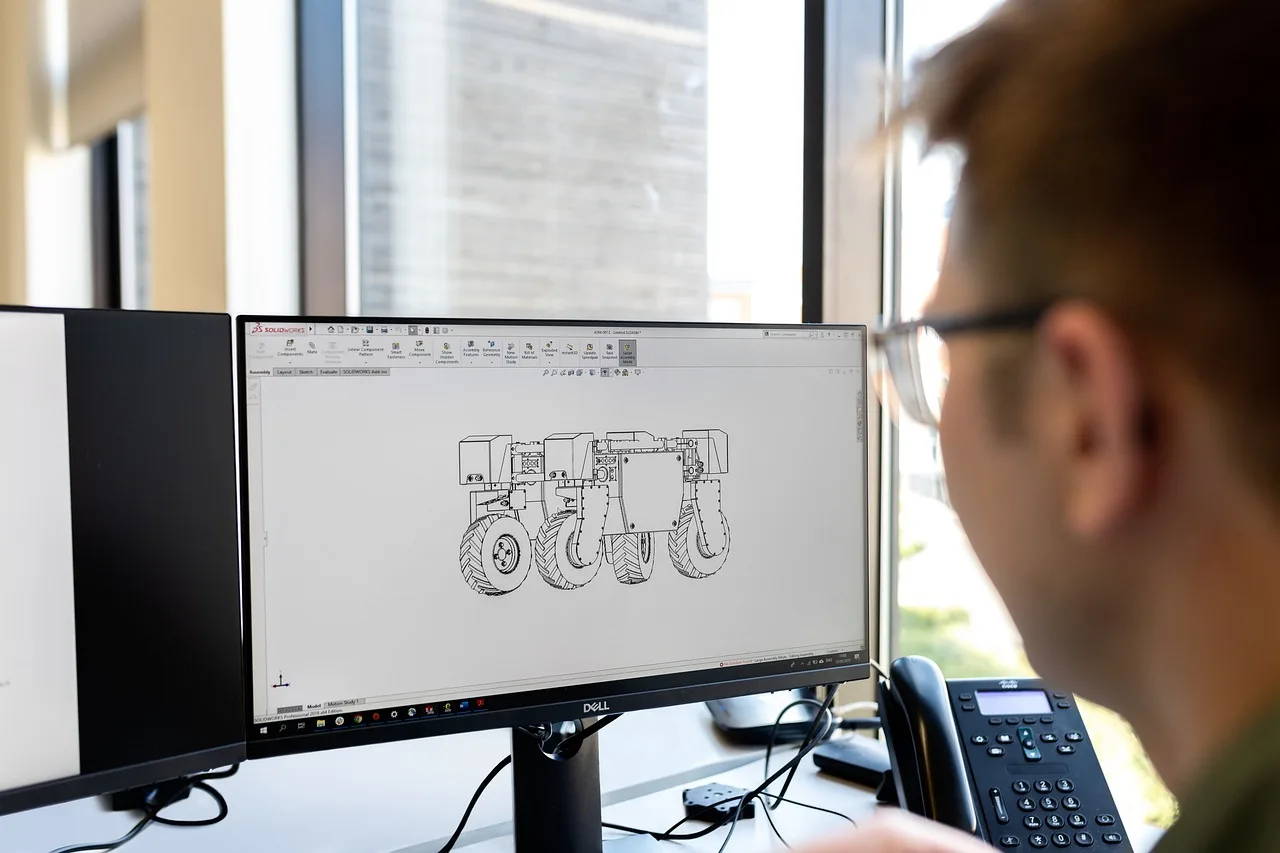 Estudante de engenharia mecânica analisando um projeto de TCC no computador