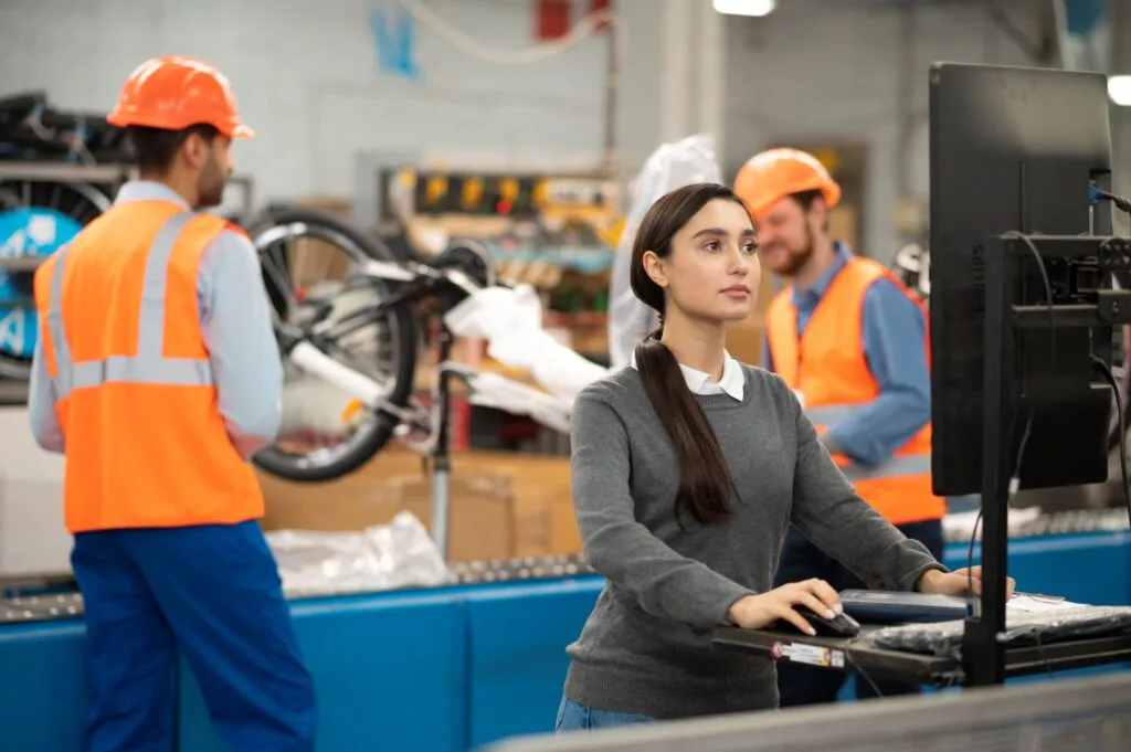 Engenheira de Produção analisando dados de produção em ambiente industrial avançado, exemplificando expertise técnica e estratégica. Imagem que destaca a importância da engenharia na otimização de processos industriais.