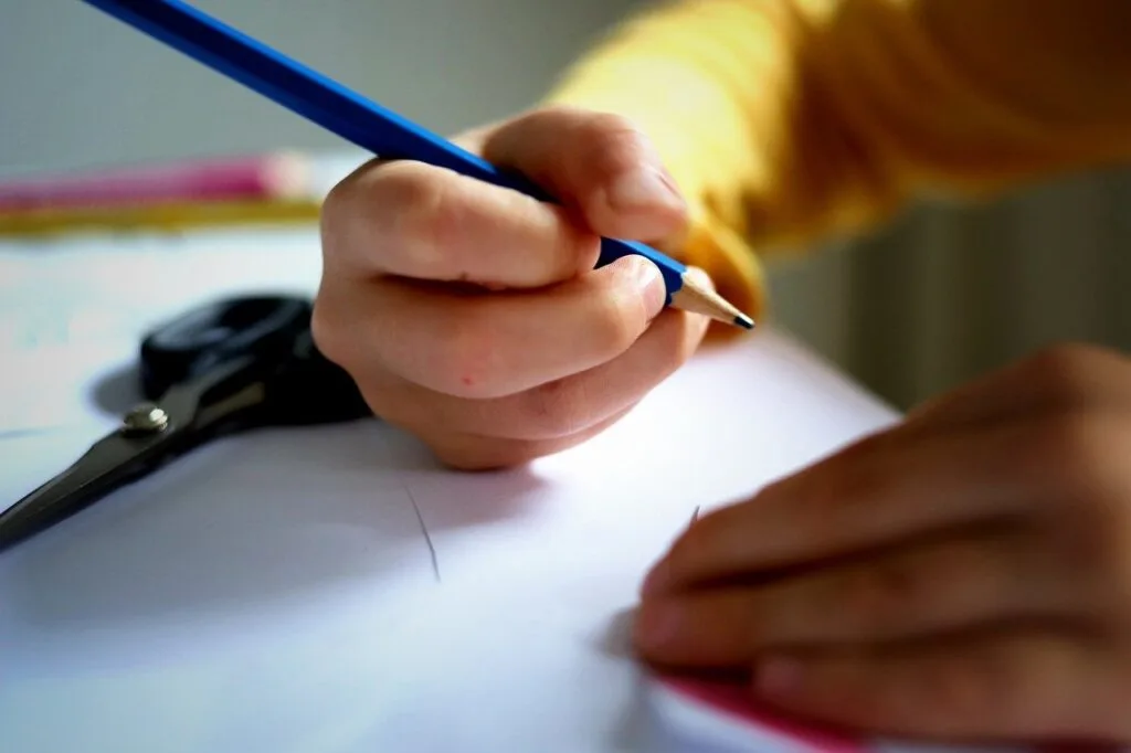 Estudante de Engenharia de Produção fazendo anotações em seu caderno durante uma sessão de estudos.